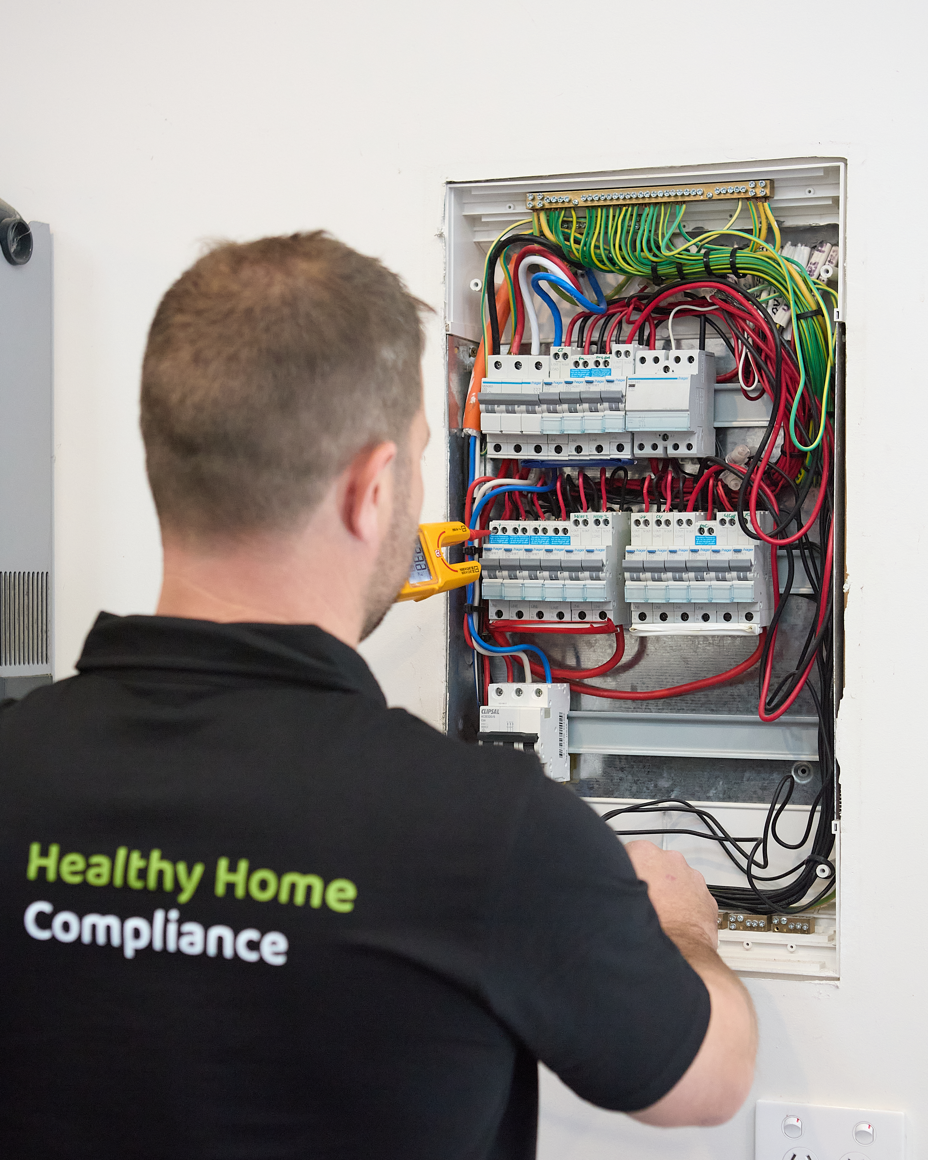 Licensed electrician testing a switchboard during an electrical safety check