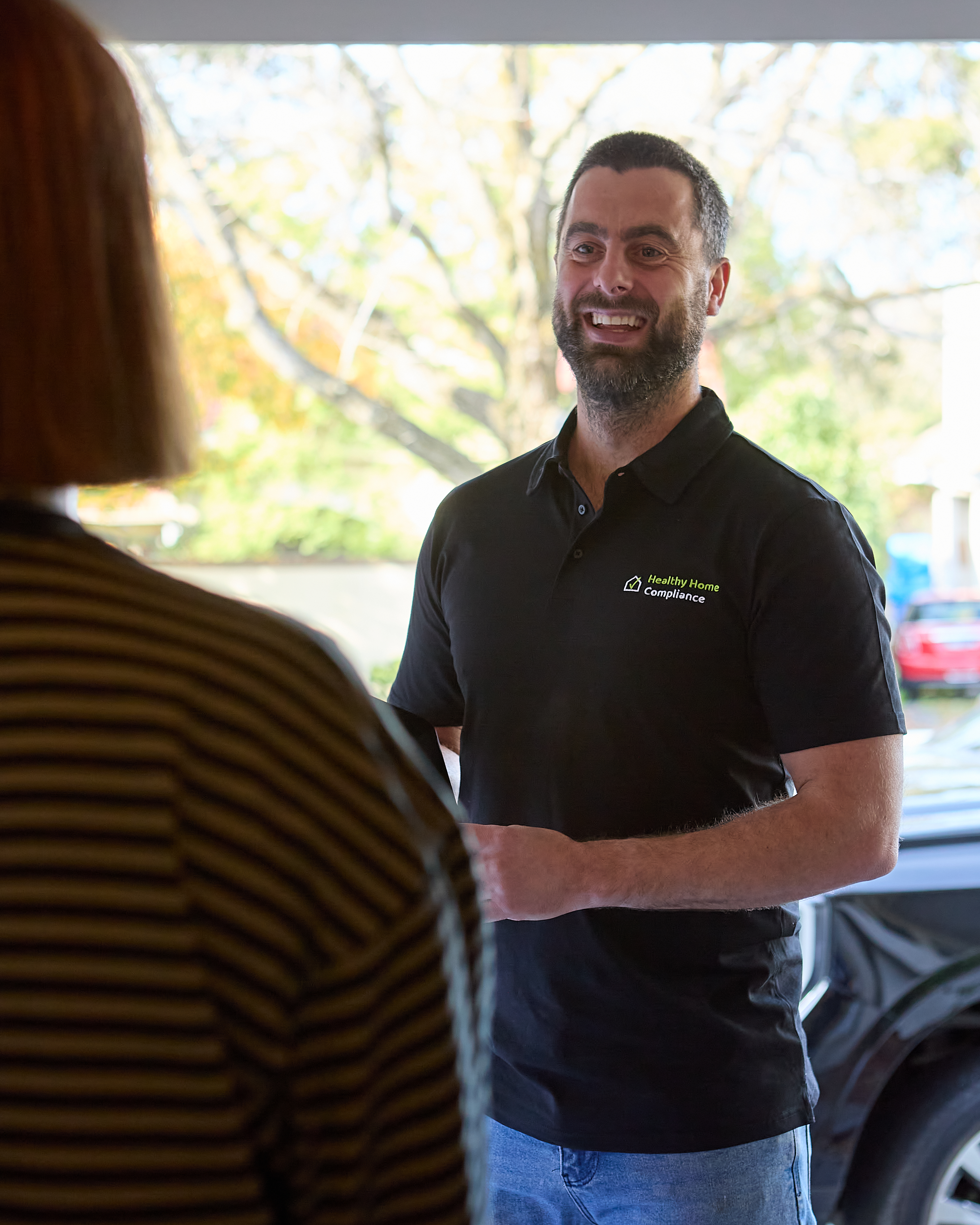 Healthy Home Compliance technician greeting a customer at the door